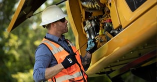 Jobsite operator taking a look under the hood in hopes of  improving CAT machinery fuel efficiency